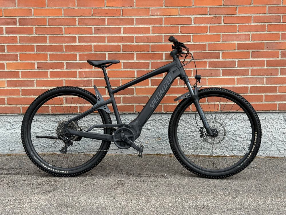 Musta Specialized Turbo Tero 4.0 -sähköpyörä tiiliseinän edessä